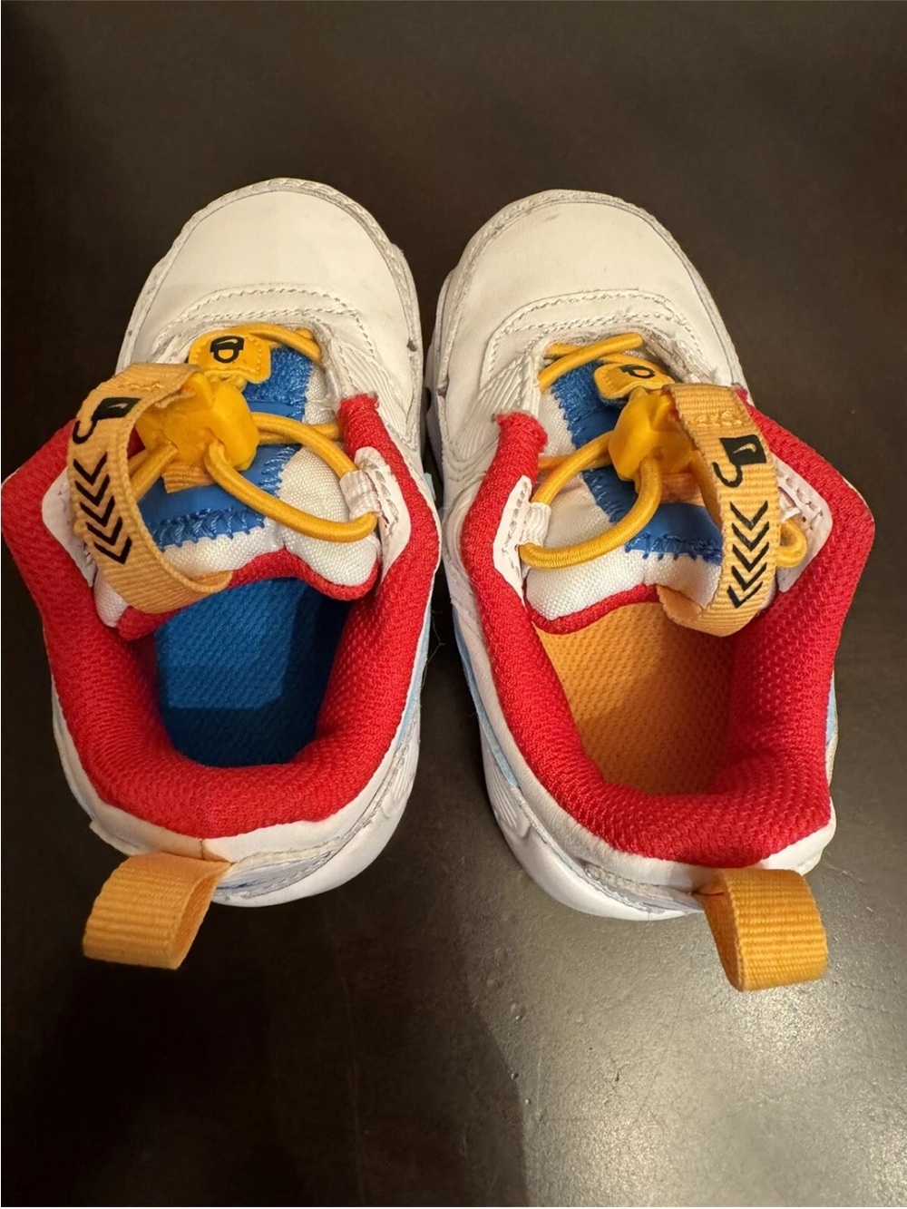 Nike Kids White Sneakers with Red, Blue and Yellow Accents